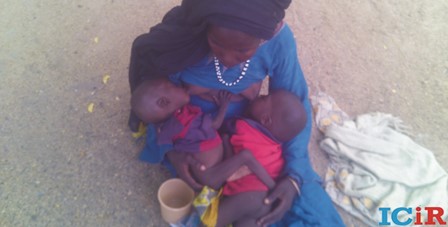 A hungry woman breastfeeds her twins 