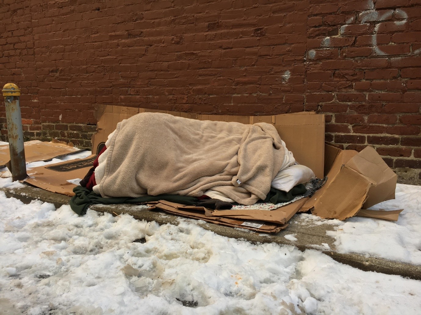 Photograph of a homeless person sleeping outside in the cold. Credit: Getty Image