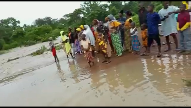 Stranded villagers cut off by the over flow of Nune river on the road