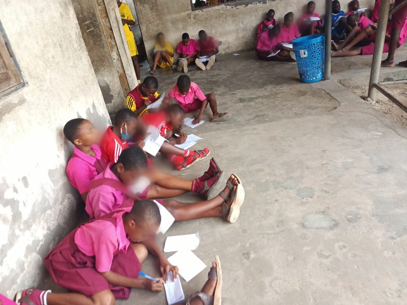 Students of Secondary Grammar School, Upenekang, Ibeno writing examination on bare floor. Credit: Ekemini Simon.