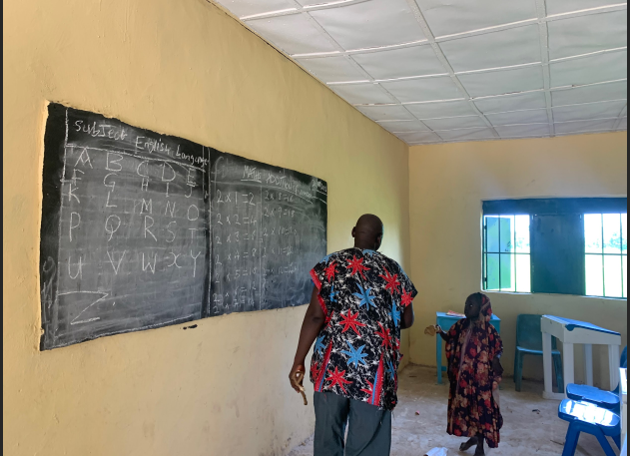 Abdullahi Ahmed teaches a pupil to recite the multiplication table. Photo: Chigozie Victor/HumAngle.