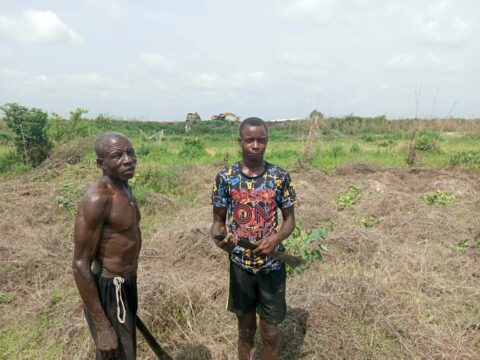 22-year old Ifeanyi with his father on the farm ravaged by flood in 2022