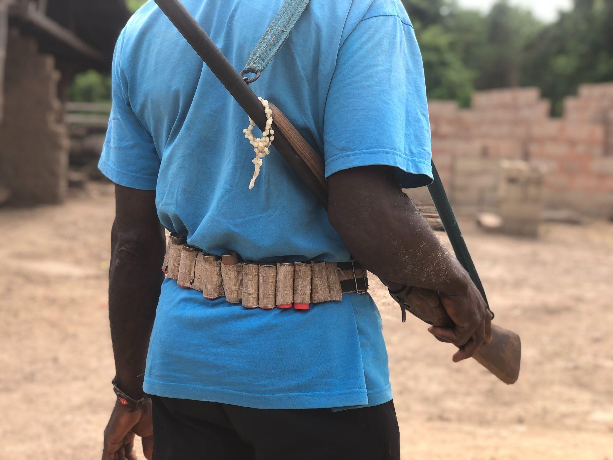 A man holding a local rifle with bullets around his waist. Photo credit: Jairus Awo/ICIR