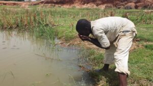 Ibrahim Yahaya drinking unclean water from a pond. PC: Lukman Abdulmalik