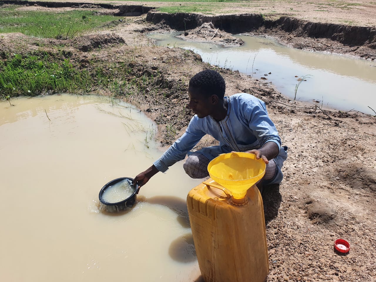A resident is fetching water from a pond. PC: Lukman Abdulamlik