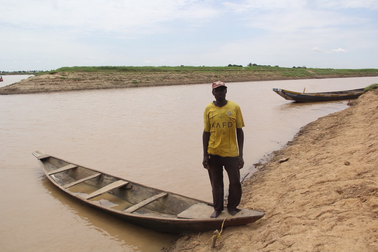 40-year-old Usman Muhammad standing on his canoe